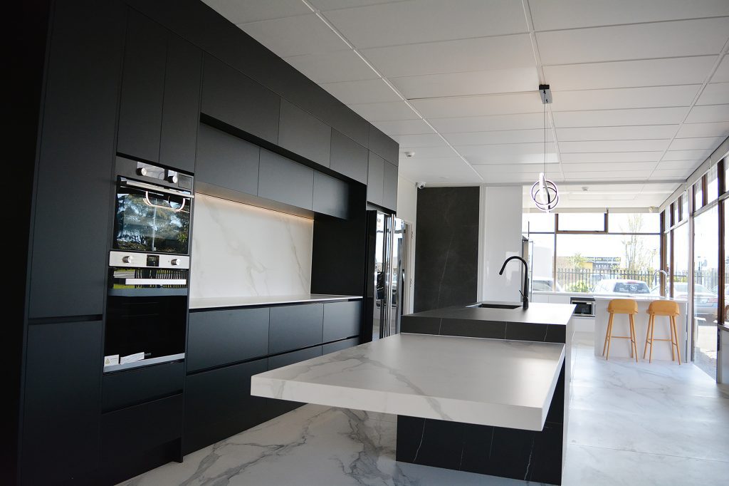 A black and white luxury kitchen with marble countertops.