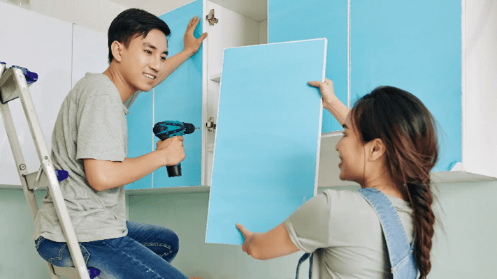 Couple assembling kitchen cupboard for a budget-friendly kitchen renovation