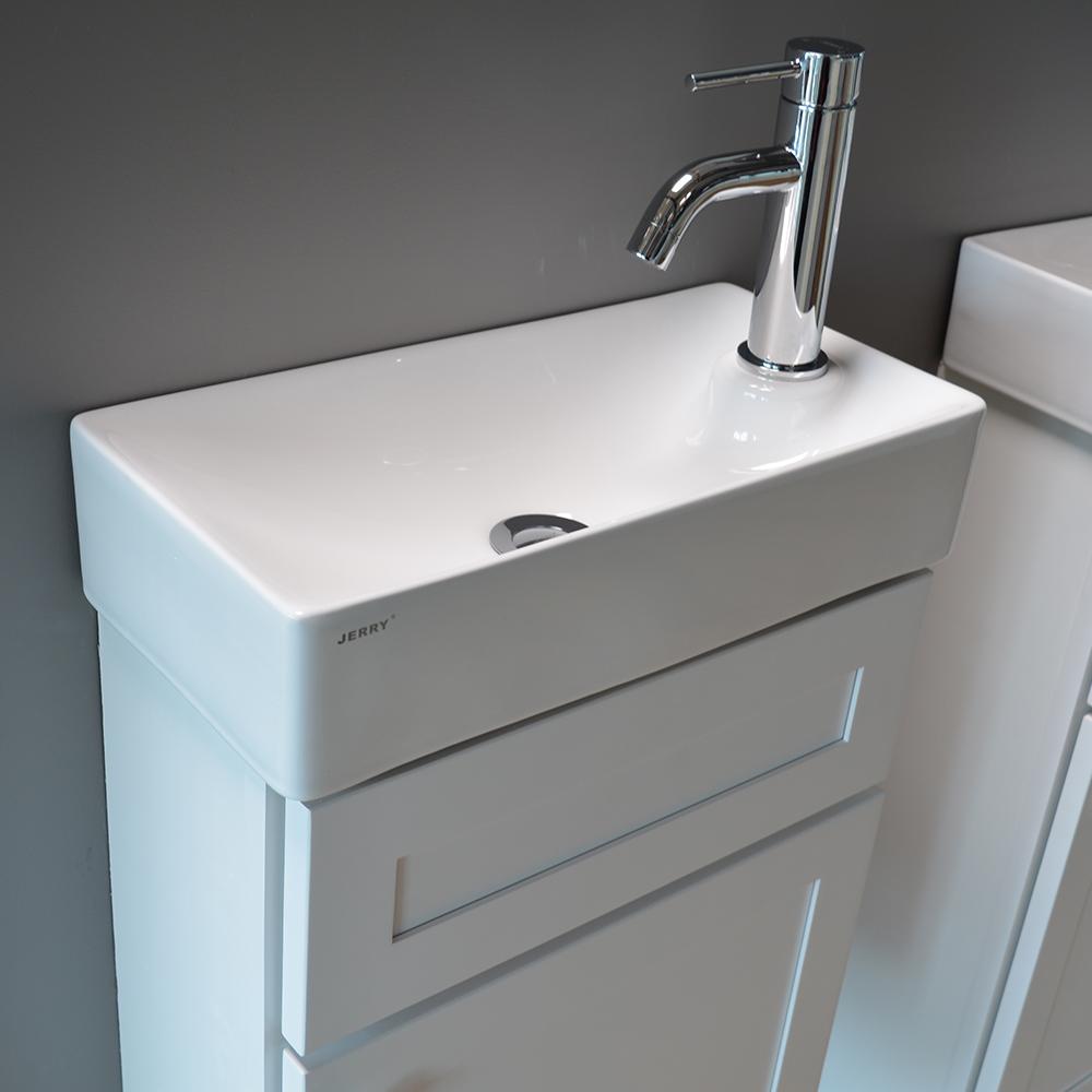 White ceramic sink on marble countertop with dark cabinet.