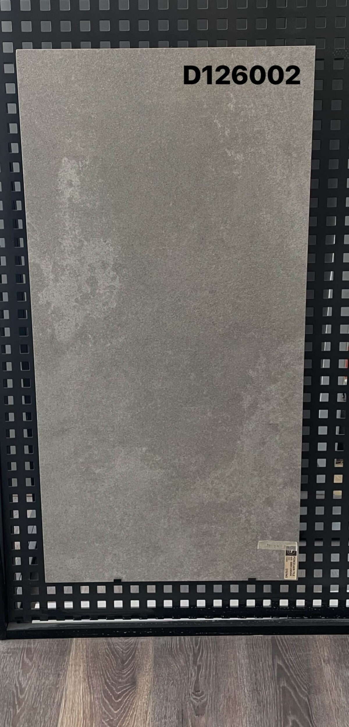 Gray tile sample labeled D126002 on display.