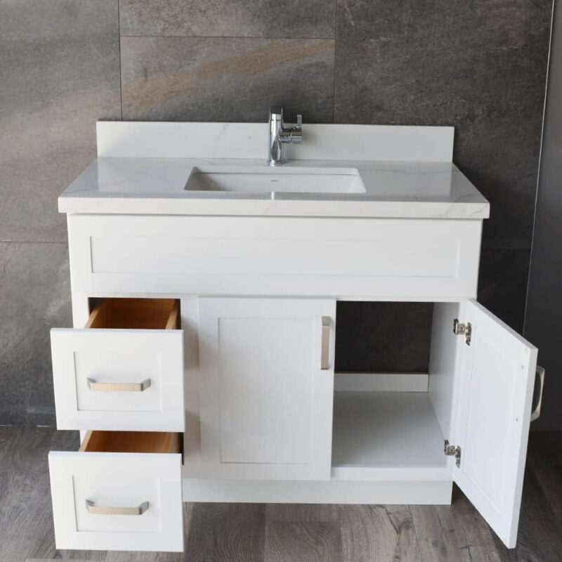 White bathroom vanity with open drawers and cabinet doors.