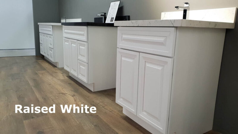 White raised kitchen cabinets on wooden floor.