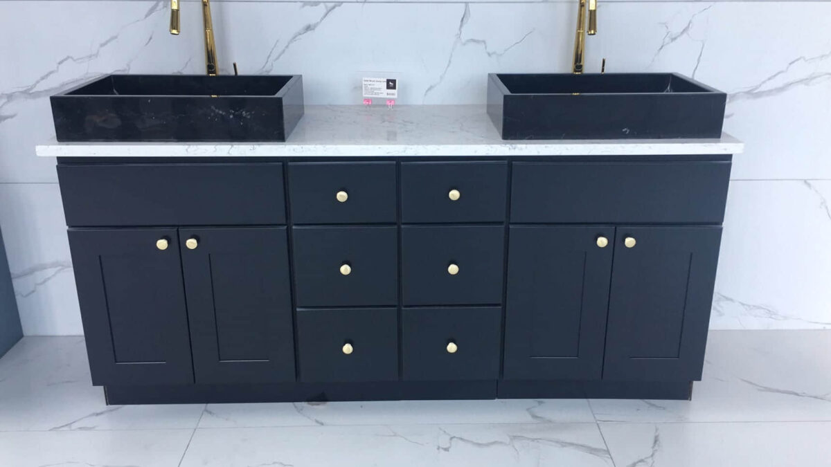 Black double sink vanity with marble countertop and gold fixtures.