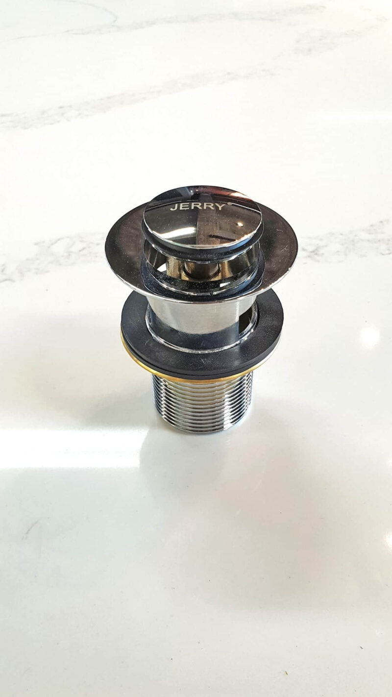 Chrome sink drain plug on white surface.