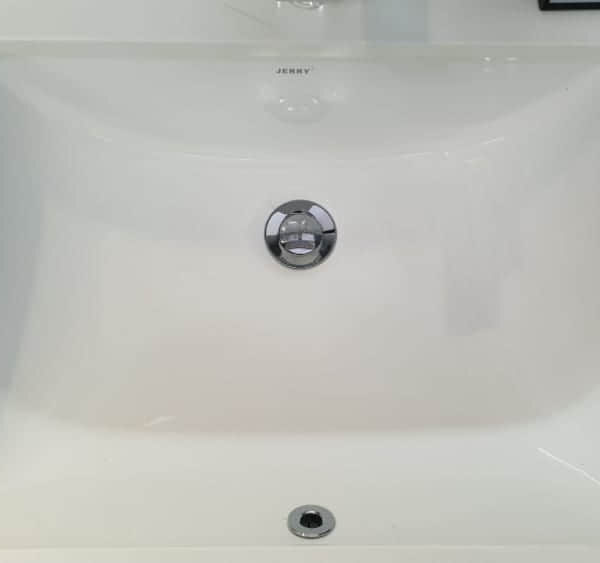 White ceramic kitchen sink with chrome drain.