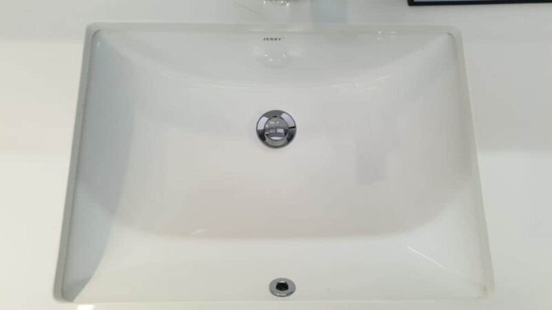 White ceramic kitchen sink with chrome drain.