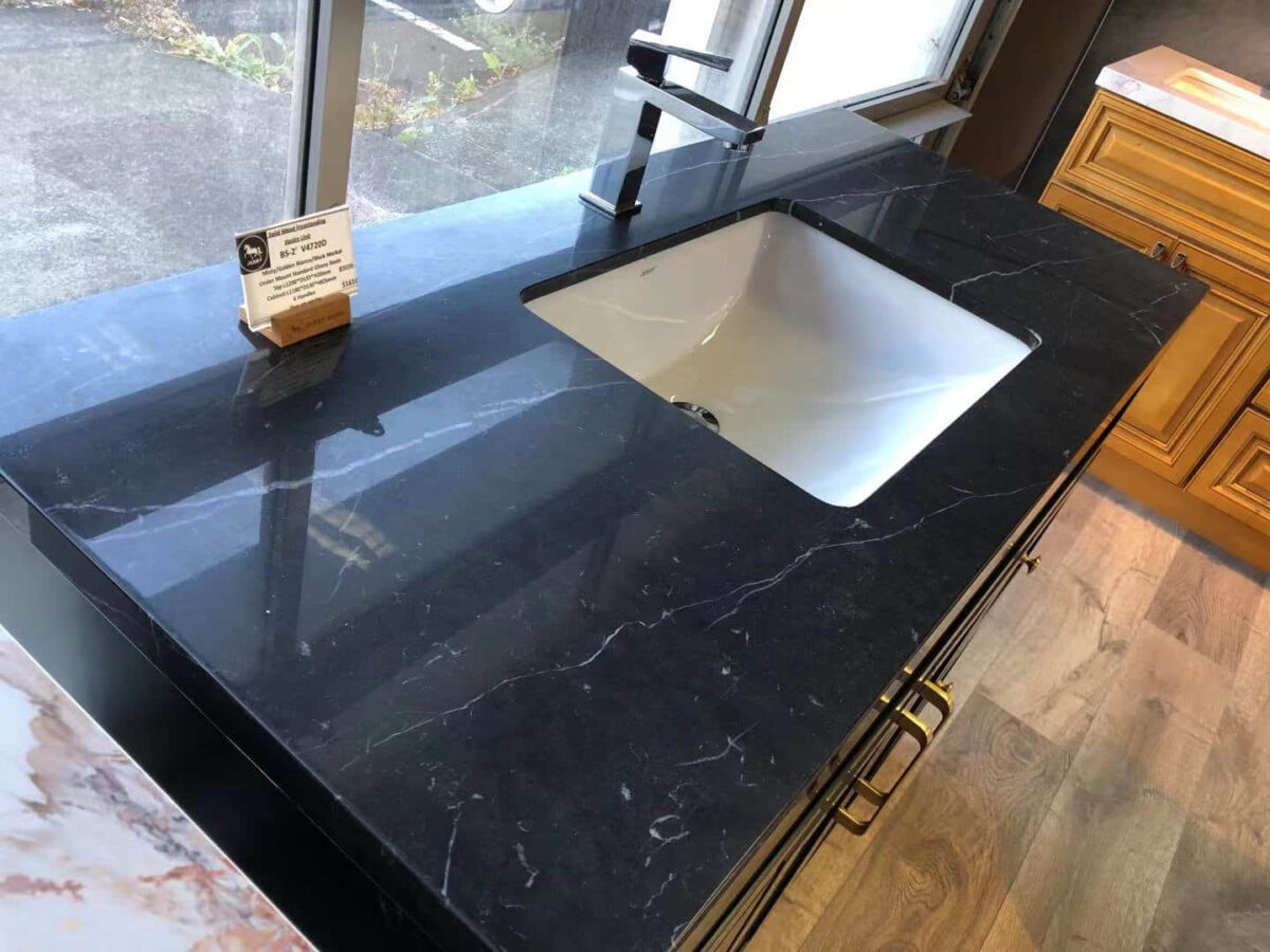 Black marble kitchen countertop with sink and faucet.
