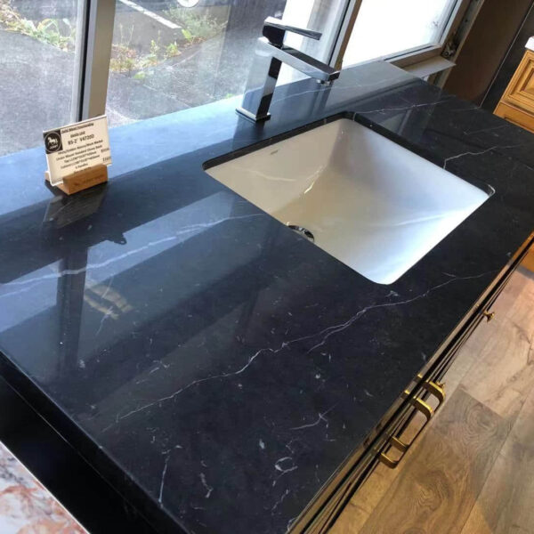 Black marble kitchen countertop with sink and faucet.