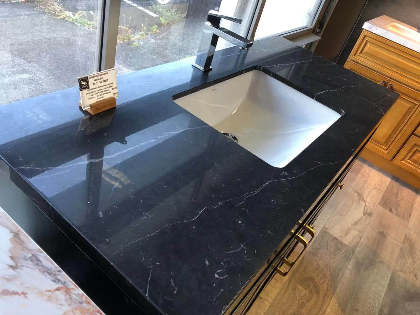 Black marble kitchen countertop with sink and faucet.
