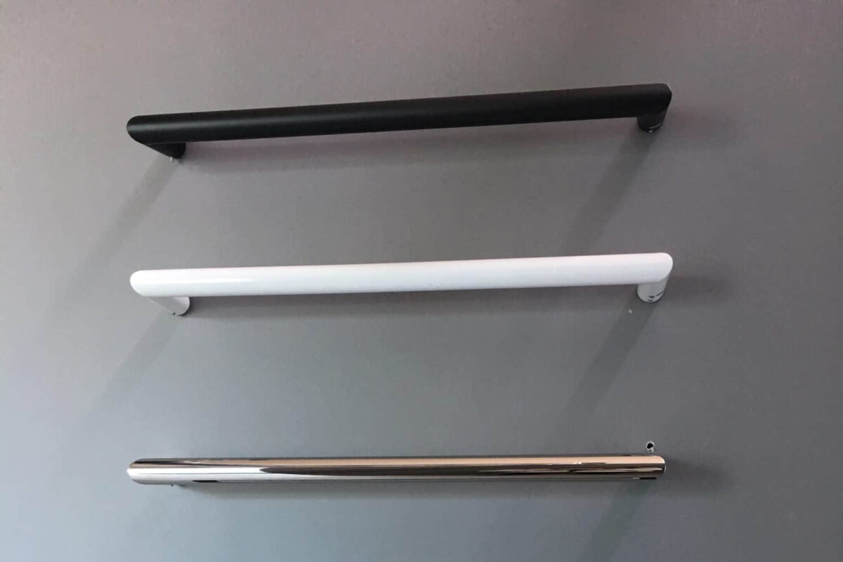 Three modern kitchen cabinet handles in black, white, and chrome.