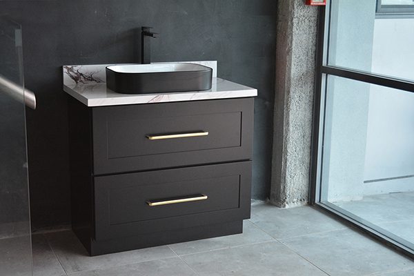 Black freestanding vanity with marble countertop and modern sink.
