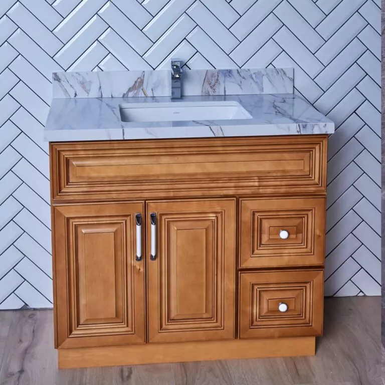 Wooden bathroom vanity with marble countertop and herringbone tile backsplash.