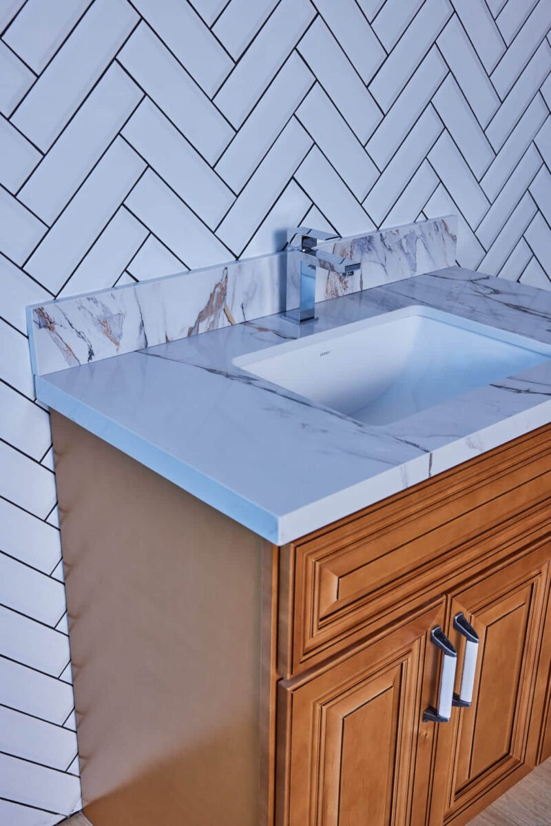 Marble countertop with sink and wooden cabinet.