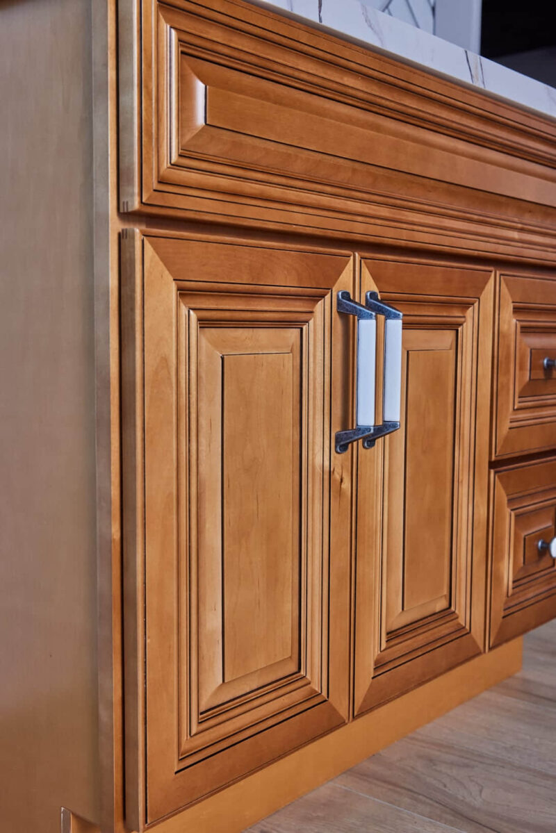 Wooden kitchen cabinet with detailed paneling and modern handles.