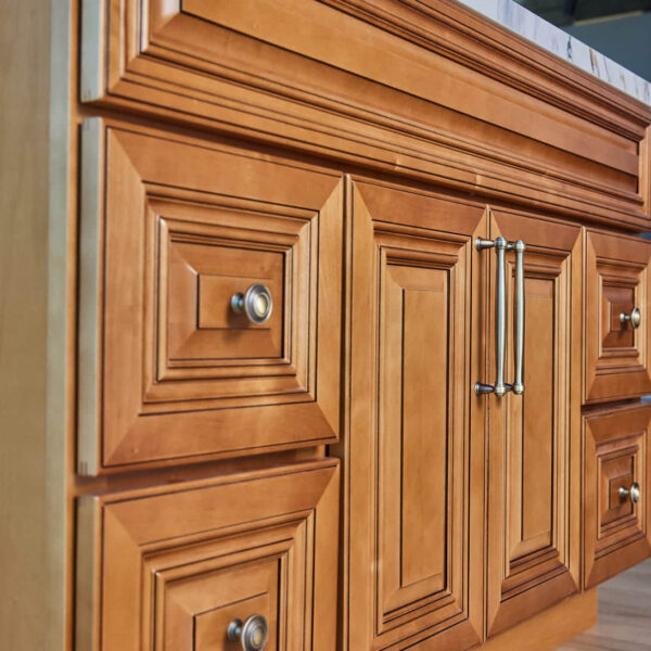 Wooden kitchen cabinet with ornate paneling and metal handles.