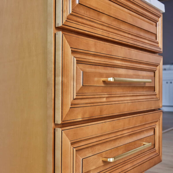 Wooden kitchen cabinet with brass handles.