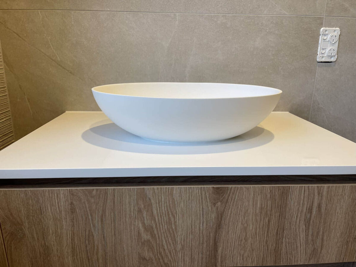 Modern custom bathroom vanity with white basin and wood finish.