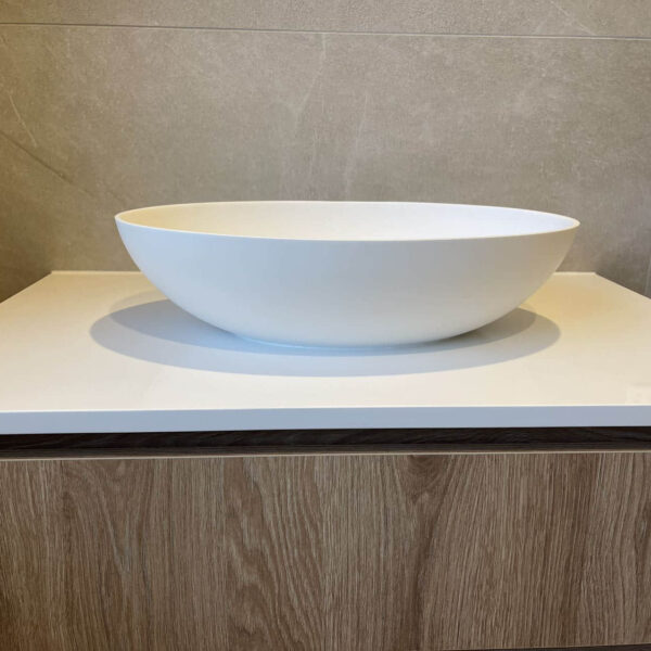 Modern custom bathroom vanity with white basin and wood finish.