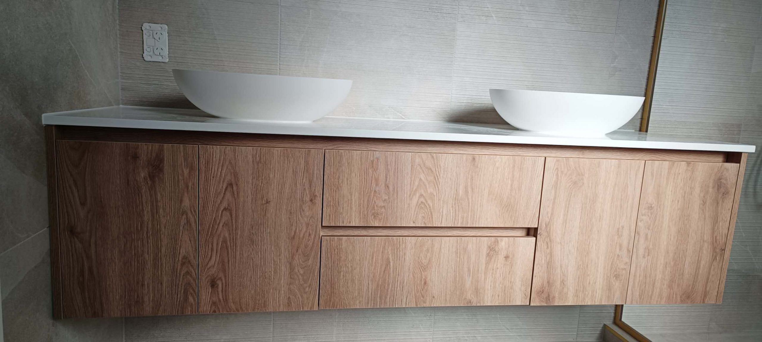 Custom bathroom vanity with dual sinks and wooden finish.