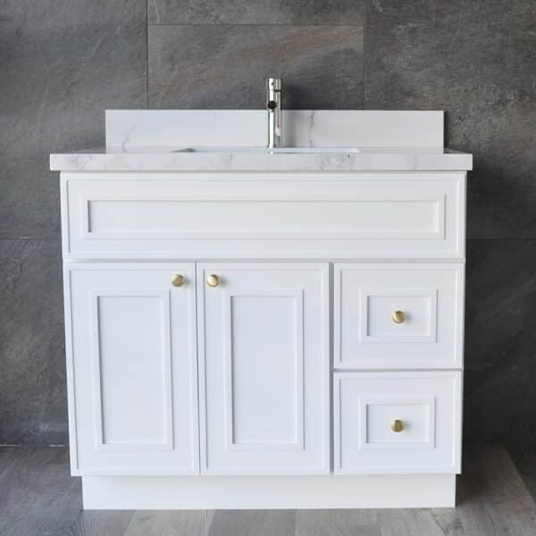 White bathroom vanity with marble countertop and gold knobs.