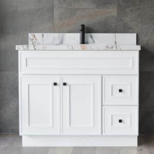 White bathroom vanity with marble countertop and black faucet.