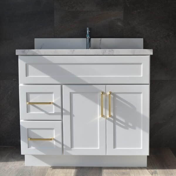 White bathroom vanity with gold handles and marble countertop.