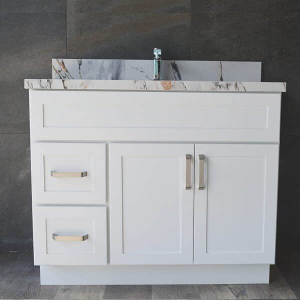 White bathroom vanity with marble countertop and modern faucet.