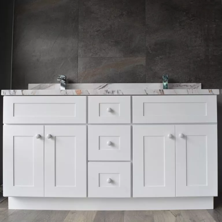 White bathroom vanity with marble countertop and dual faucets.