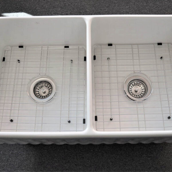 Double kitchen sink with metal grids and drains.