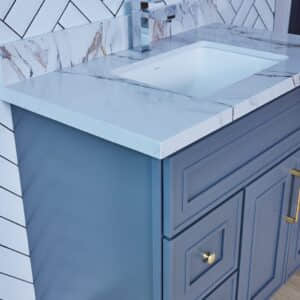 Blue bathroom vanity with marble countertop and modern faucet.