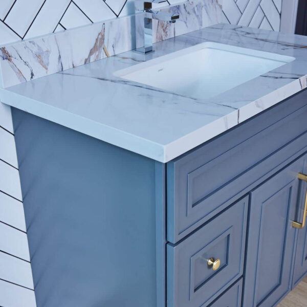 Blue bathroom vanity with marble countertop and modern faucet.