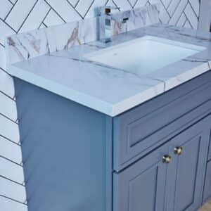 Blue bathroom vanity with marble countertop and modern faucet.