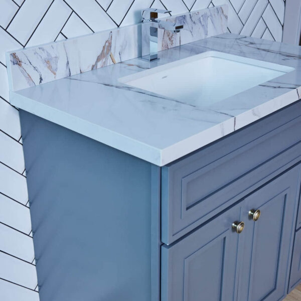 Blue bathroom vanity with marble countertop and modern faucet.