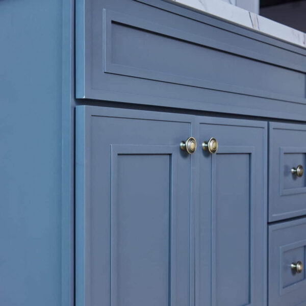 Blue kitchen cabinet with brass knobs.