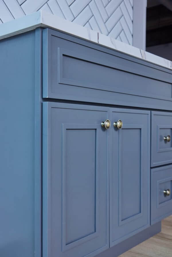 Blue kitchen cabinet with brass knobs.
