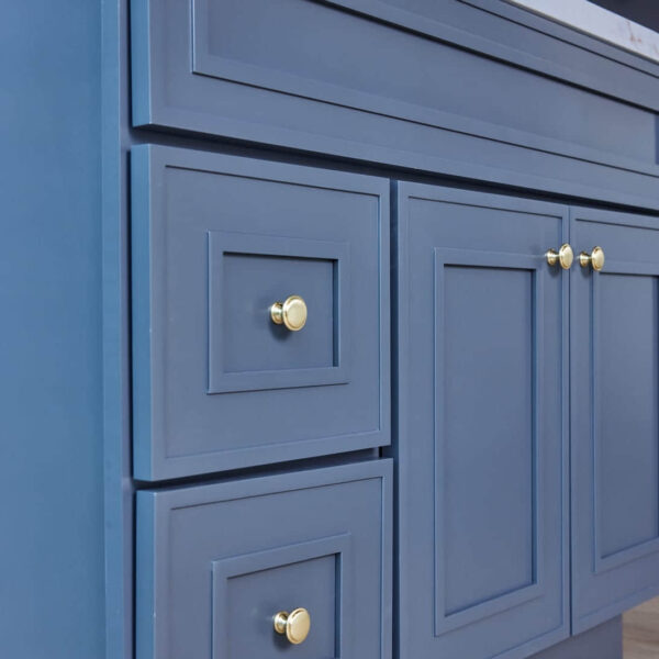 Blue kitchen cabinets with gold knobs.