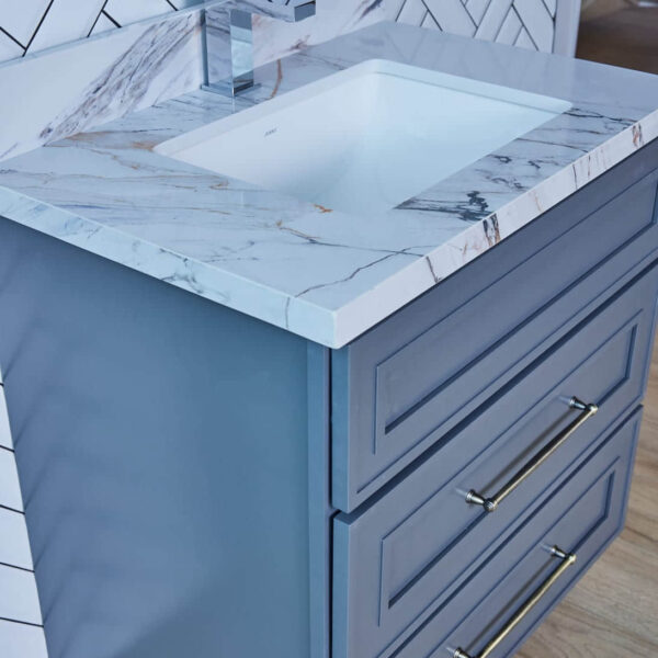 Blue bathroom vanity with marble countertop and modern faucet.