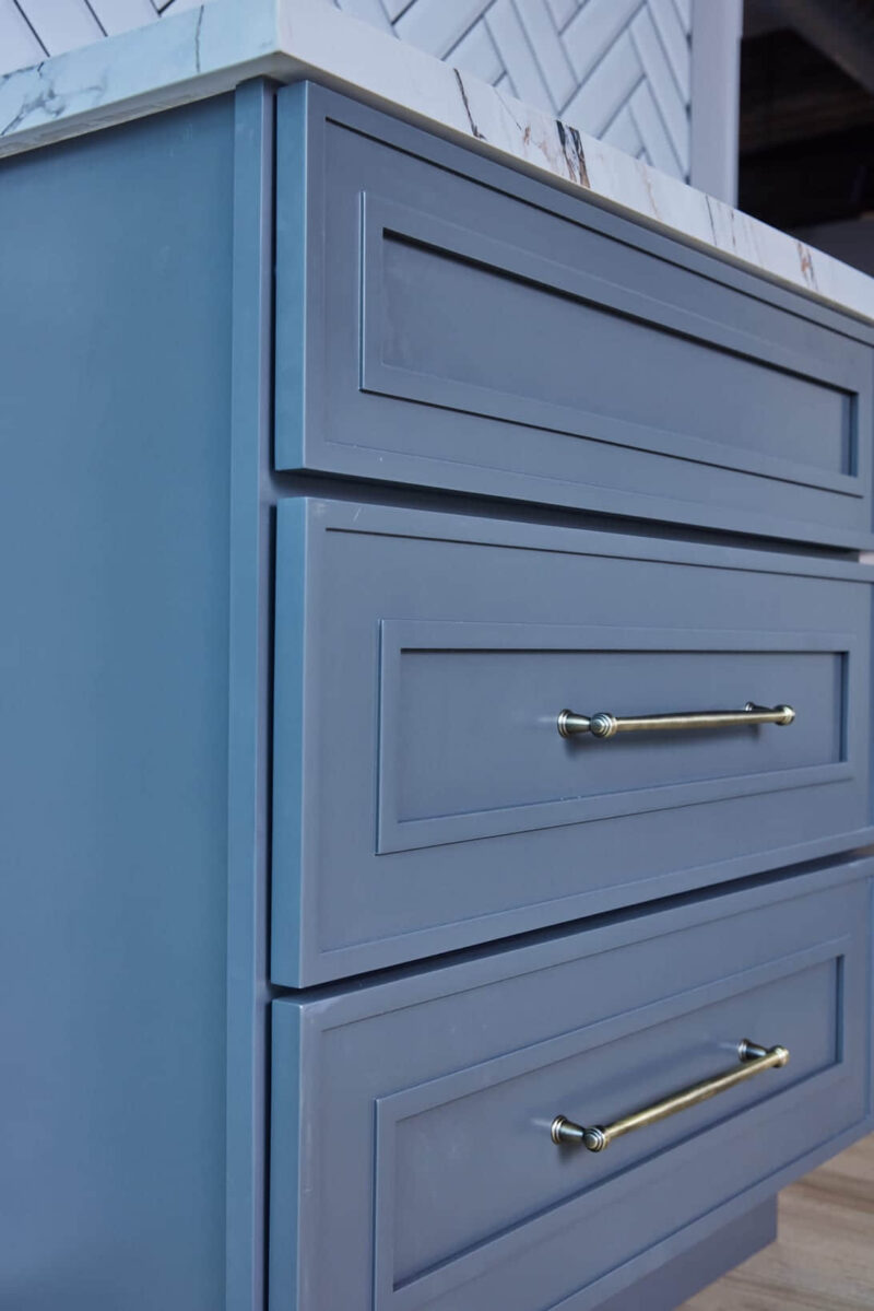 Blue kitchen cabinet drawers with silver handles.