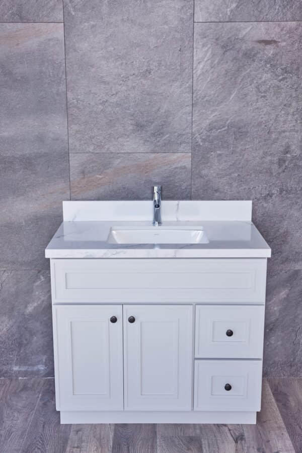 White bathroom vanity with marble countertop and gray tiled wall background.