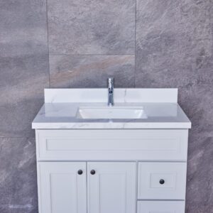 White bathroom vanity with marble countertop against gray stone wall.