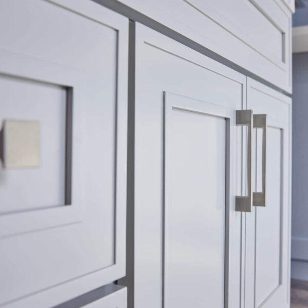 White kitchen cabinets with modern square handles.