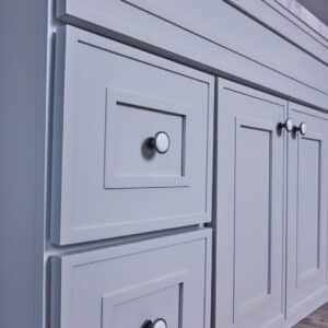 White kitchen cabinet with silver knobs.