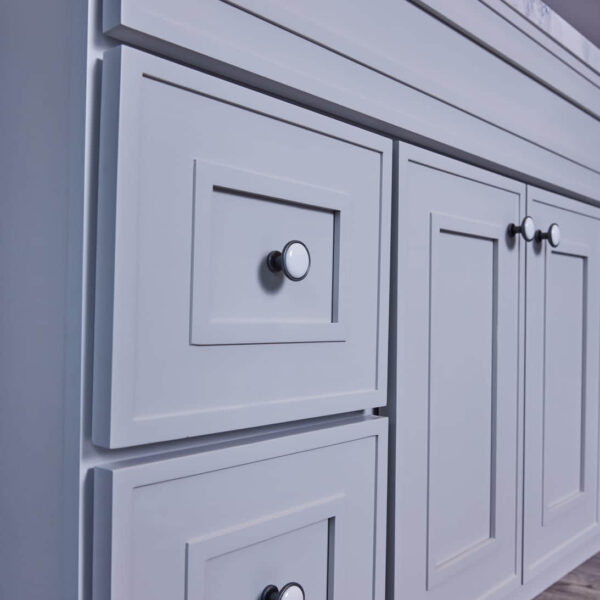 White kitchen cabinet with silver knobs.