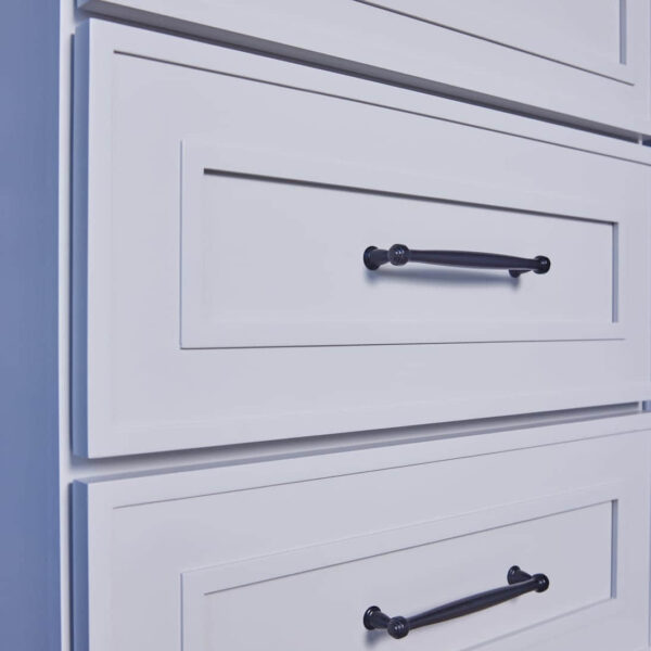 White kitchen cabinet with black handles.