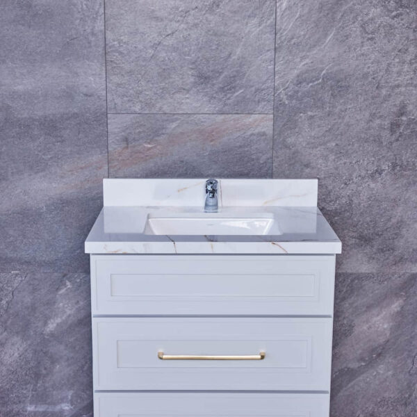 Modern bathroom vanity with marble countertop and gray tile background.