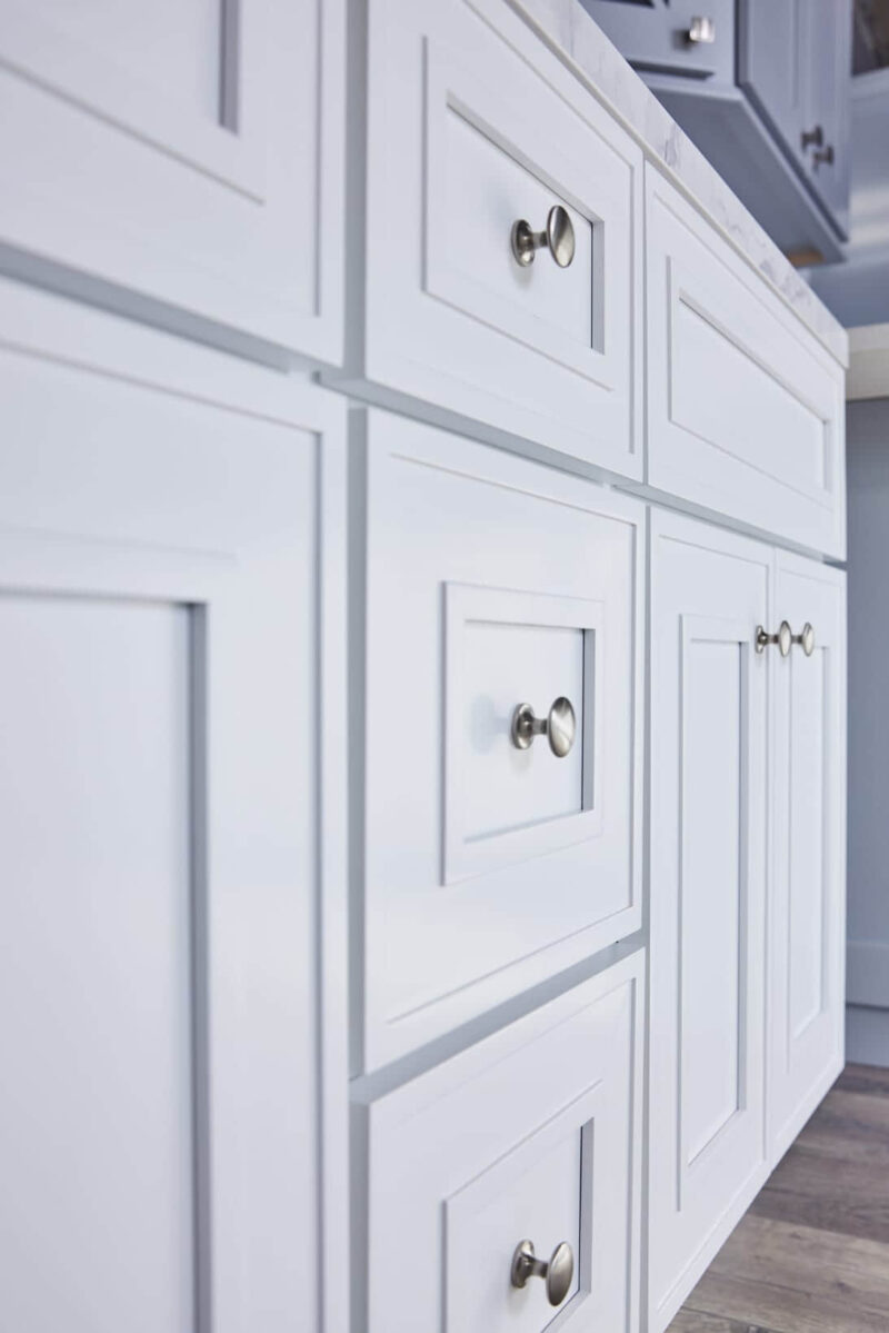 White kitchen cabinets with silver knobs.