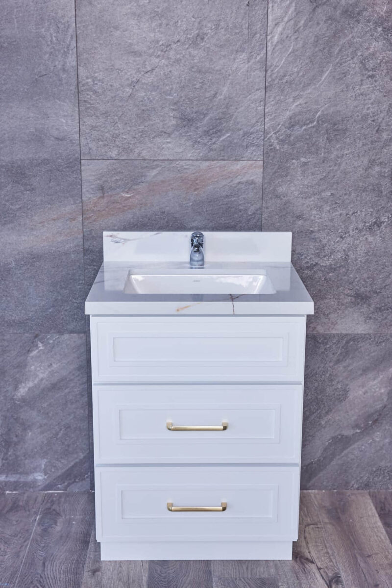 White bathroom vanity with marble countertop against gray tiled wall.