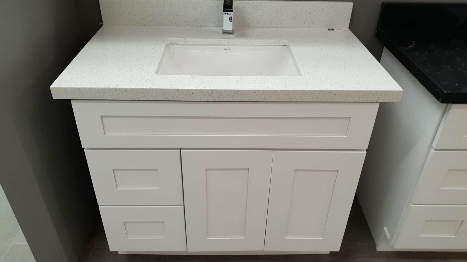 White bathroom vanity with sink and faucet.