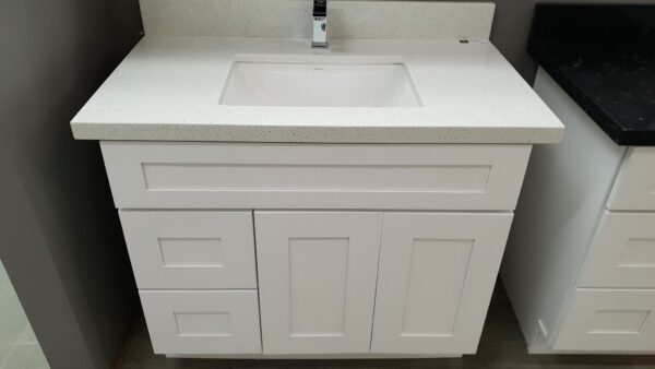 White bathroom vanity with sink and faucet.