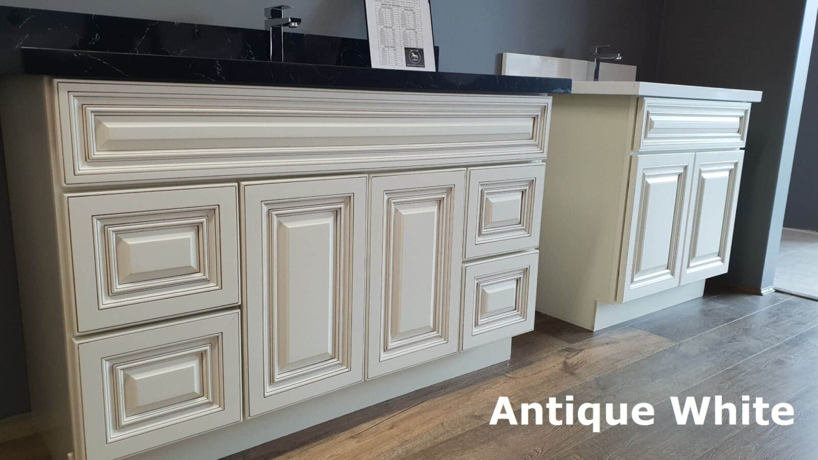 Antique White kitchen cabinets with intricate panel design and dark countertop.